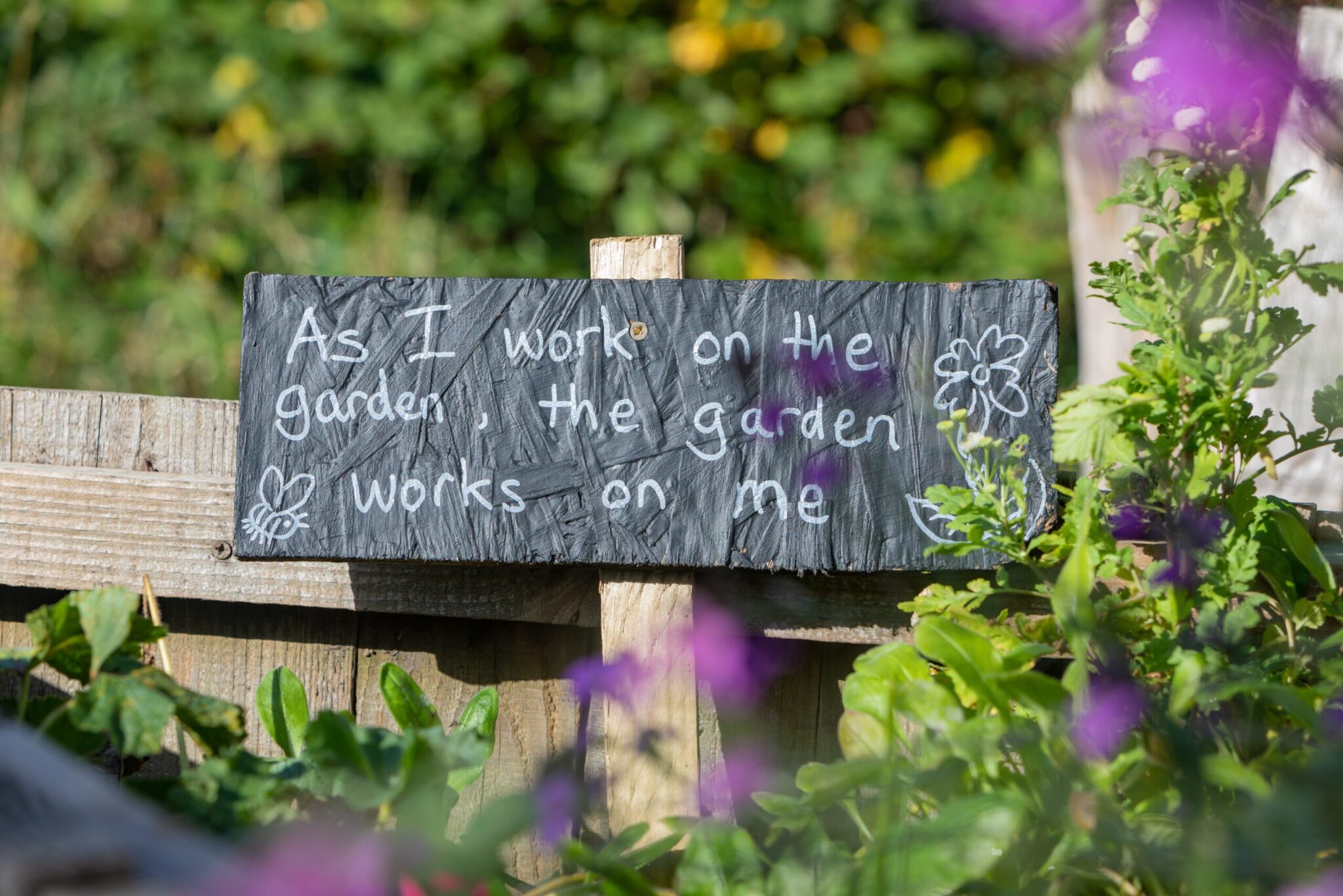 Garden sign that reads "As I work on the garden, the garden works on me"