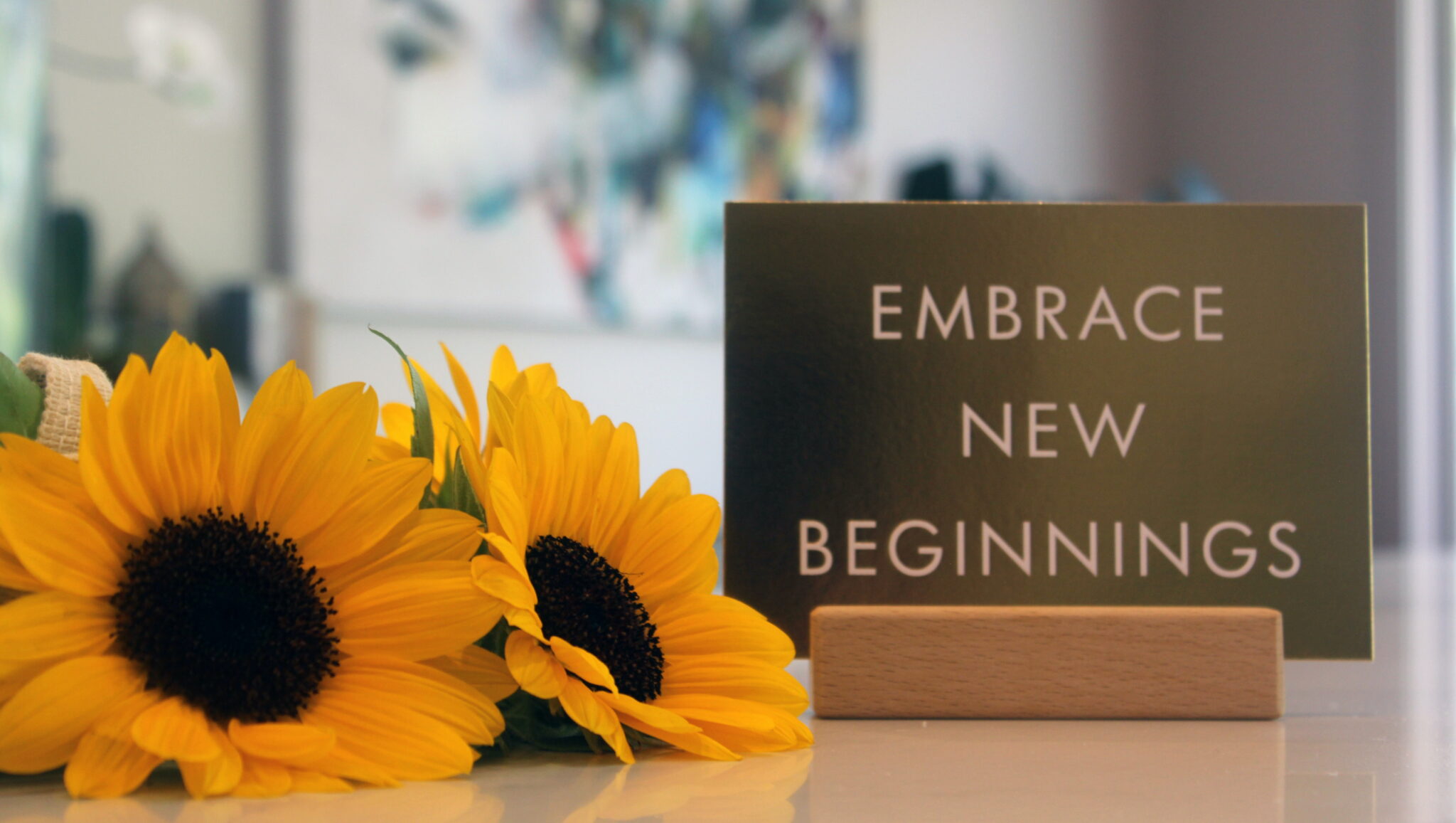 Sunflowers by sign that reads Embrace New Beginnings
