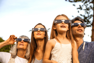 Family watching solar eclipse in glasses