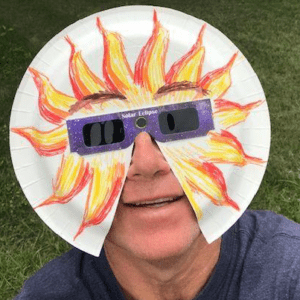 Man in solar eclipse glasses with face shield