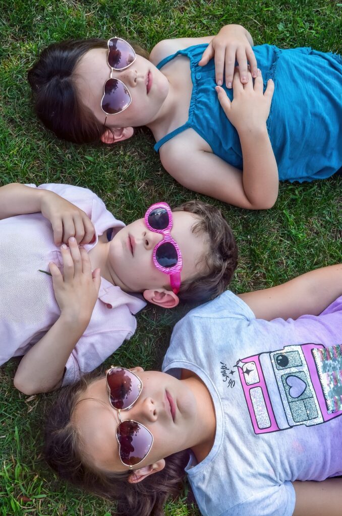 Girls lying on grass in sunglasses