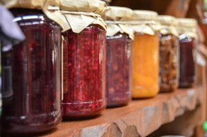 Row of colorful preserved fruits and vegetables in jars